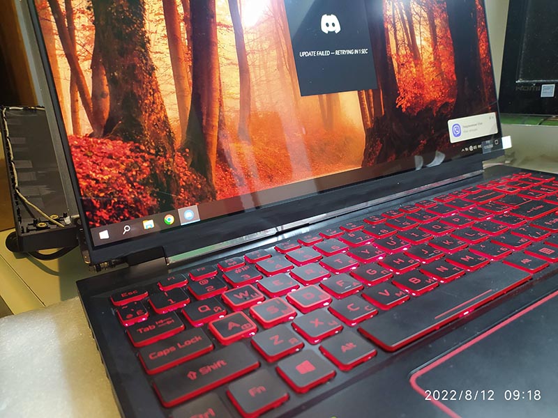Ноутбук з червоним підсвічуванням клавіатури та відкритим дисплеєм під час перевірки працездатності після ремонту.