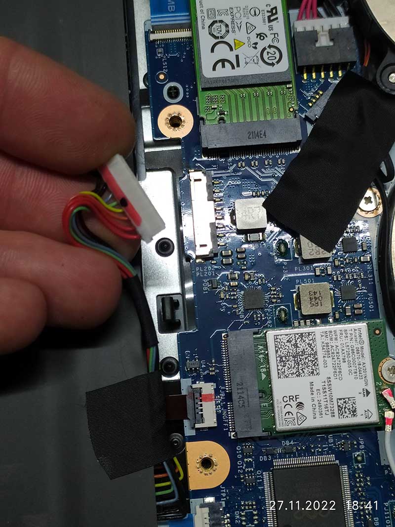 Close-up view of the internal components of an Acer laptop, highlighting the wiring and connector. The image shows the detailed circuitry, including a red, yellow, green, and black wire connected to the motherboard. Suitable for tutorials on laptop repair or internal hardware upgrades
