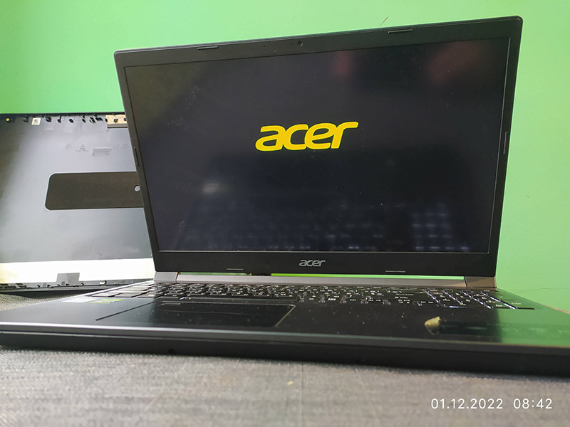 На зображенні представлено процес ремонту ноутбука Acer у сервісному центрі. На екрані ноутбука видно логотип Acer, що свідчить про стадію початкового завантаження пристрою. Поряд із ноутбуком знаходиться знята задня панель корпусу, що демонструє процес розбору пристрою для проведення діагностики та ремонту. Дата на зображенні (01.12.2022) показує час проведення обслуговування. Це фото може використовуватися для надання інформації користувачам про послуги з ремонту ноутбуків Acer, підвищуючи релевантність сайту у пошукових запитах, пов’язаних з ремонтом техніки Acer.
