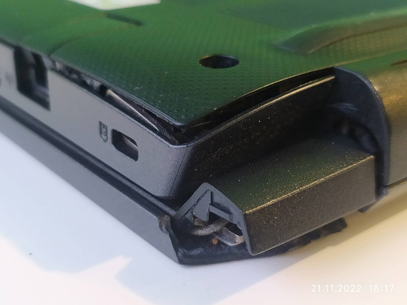 Зображення показує деталі ноутбука Acer з пошкодженим корпусом біля шарніру. Видно механічне руйнування корпусу, деформацію пластику та розриви, що сталися внаслідок неправильного відкривання або зносу механізму.