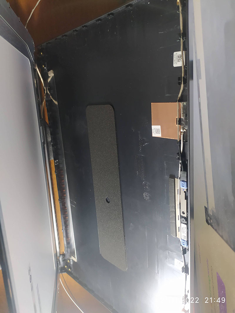 Показано ноутбук без встановленого дисплея, що демонструє монтажні компоненти для екрану, включаючи місця для кріплення та шлейфи. Видно внутрішню частину ноутбука під екраном, де підключаються кабелі та інші компоненти.