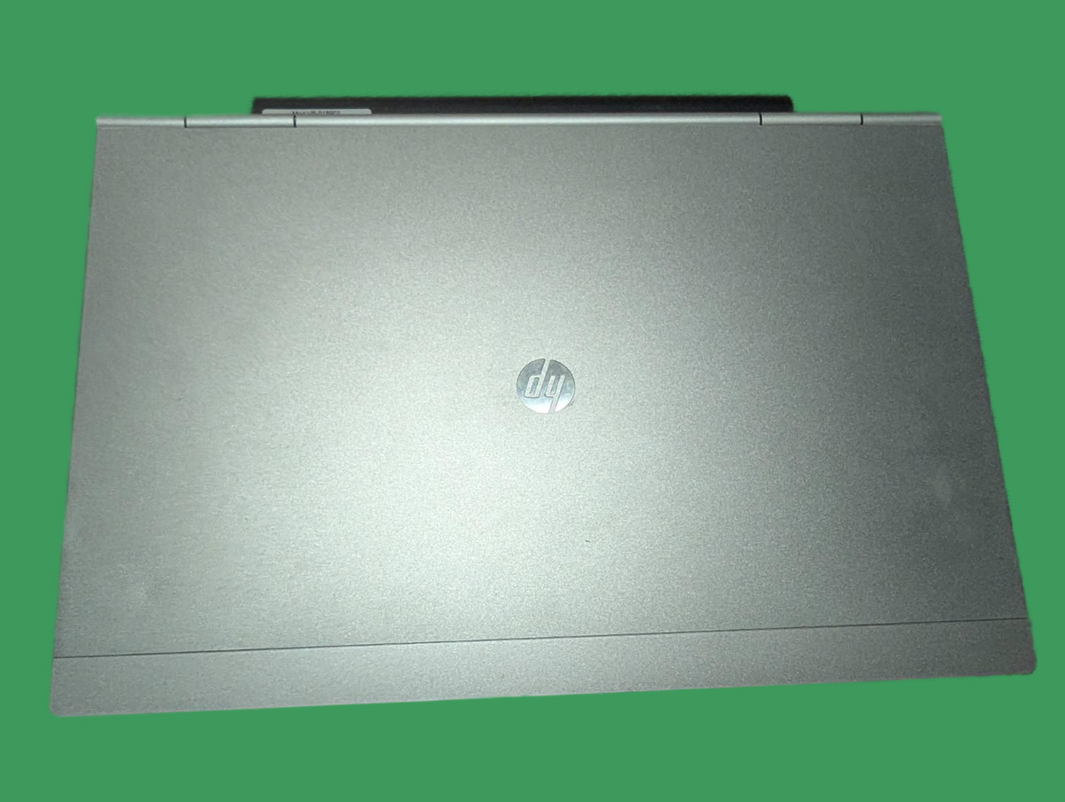 Зображення ноутбука HP EliteBook 2570p з кришкою сріблястого кольору та логотипом HP. Фокус на зовнішньому стані корпусу.