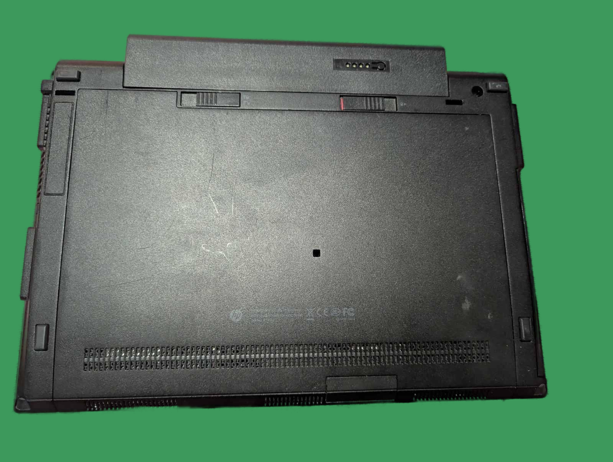 Зображення нижньої панелі ноутбука HP EliteBook 2570p з вентиляційними отворами та кріпленням батареї. Виділено конструкцію і стан поверхні.