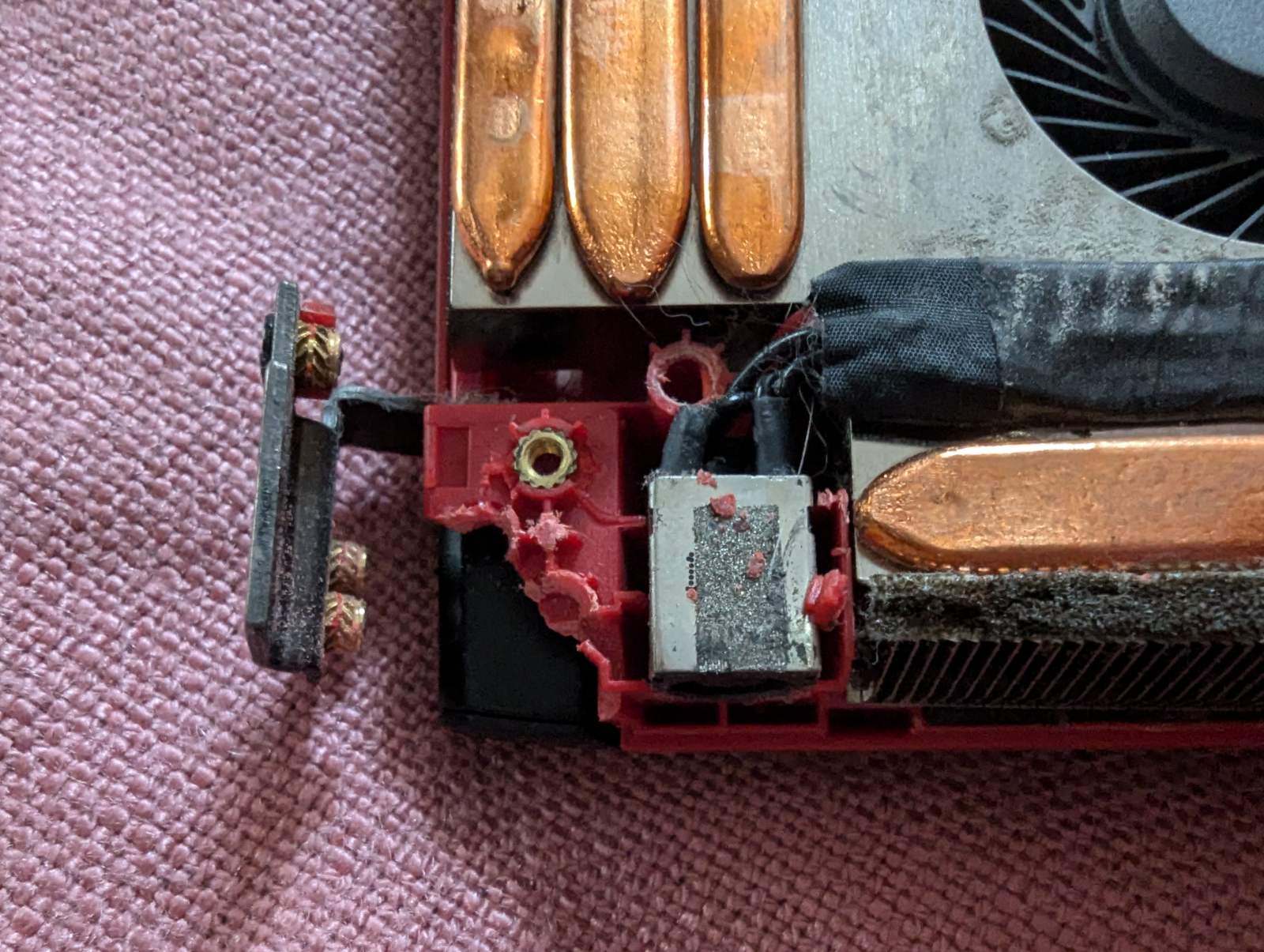 Пошкодження корпусу ноутбука MSI біля роз'єму живлення. Видно зламаний пластик, кріплення, та пил біля системи охолодження.