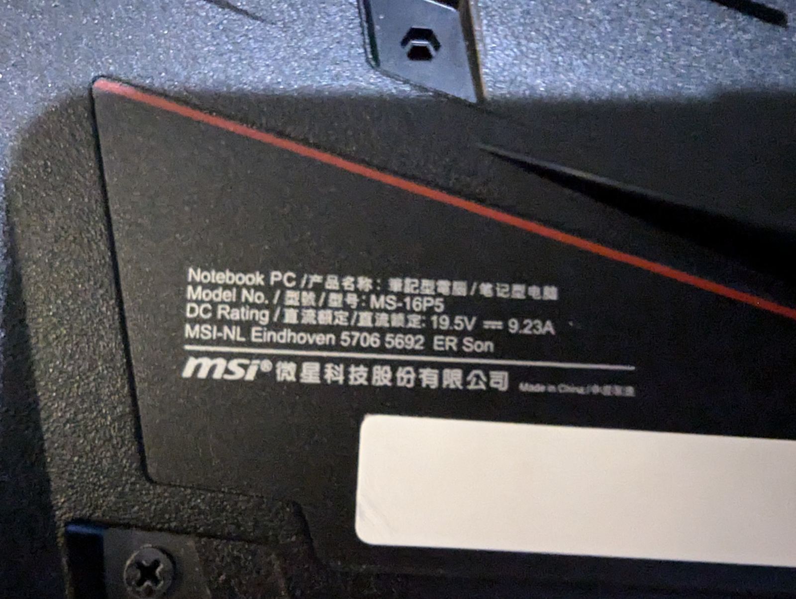 Зображення задньої панелі ноутбука MSI із серійною табличкою, на якій видно технічну інформацію, включаючи модель ноутбука (MS-16P5), технічні характеристики живлення (19.5V, 9.23A), а також зазначено виробника - MSI-NL Eindhoven. На зображенні також є логотип MSI та інформація про країну виробництва (Китай).