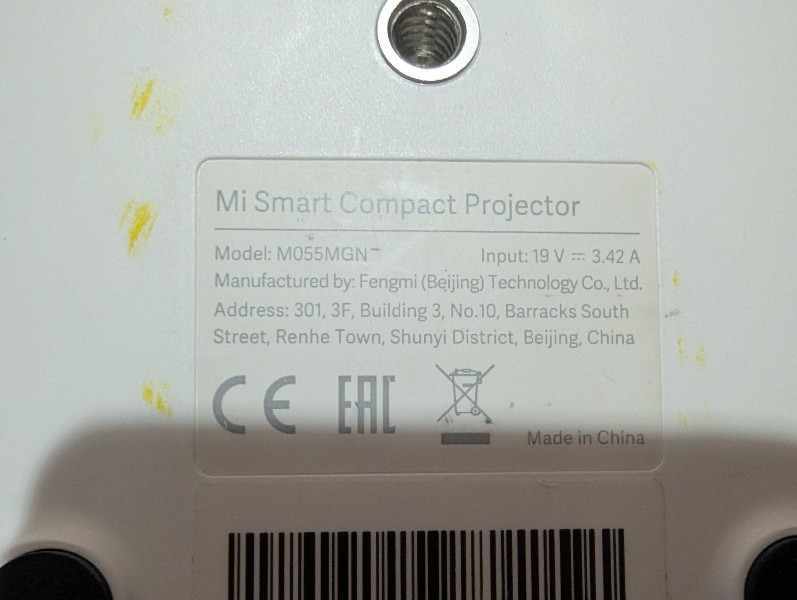 Шильдик з технічними характеристиками проектора Xiaomi Mi Smart Compact Projector M055MGN: модель, виробник Fengmi (Beijing) Technology Co., Ltd., параметри живлення 19V 3.42A. Зображення підтверджує оригінальність пристрою.