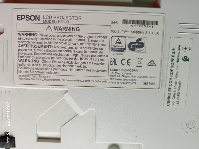 Інформаційна наклейка Epson EB-X05 з характеристиками Інформаційна наклейка на задній панелі проектора Epson EB-X05. Вказані технічні характеристики, модель, серійний номер, а також попередження про безпеку при заміні лампи чи інших компонентів.