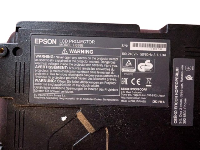 Технічна інформація проектора Epson H838B Наклейка з технічними характеристиками проектора Epson H838B, включаючи модель, серійний номер і попередження щодо безпеки.