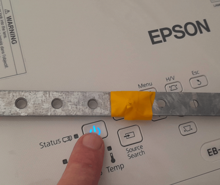 Кнопка живлення проектора Epson EB-X06 з індикатором статусу. Вимкнення проектора Epson EB-X06 через кнопку живлення зі світлодіодним індикатором. Процес перевірки після заміни лампи та ремонту пристрою.