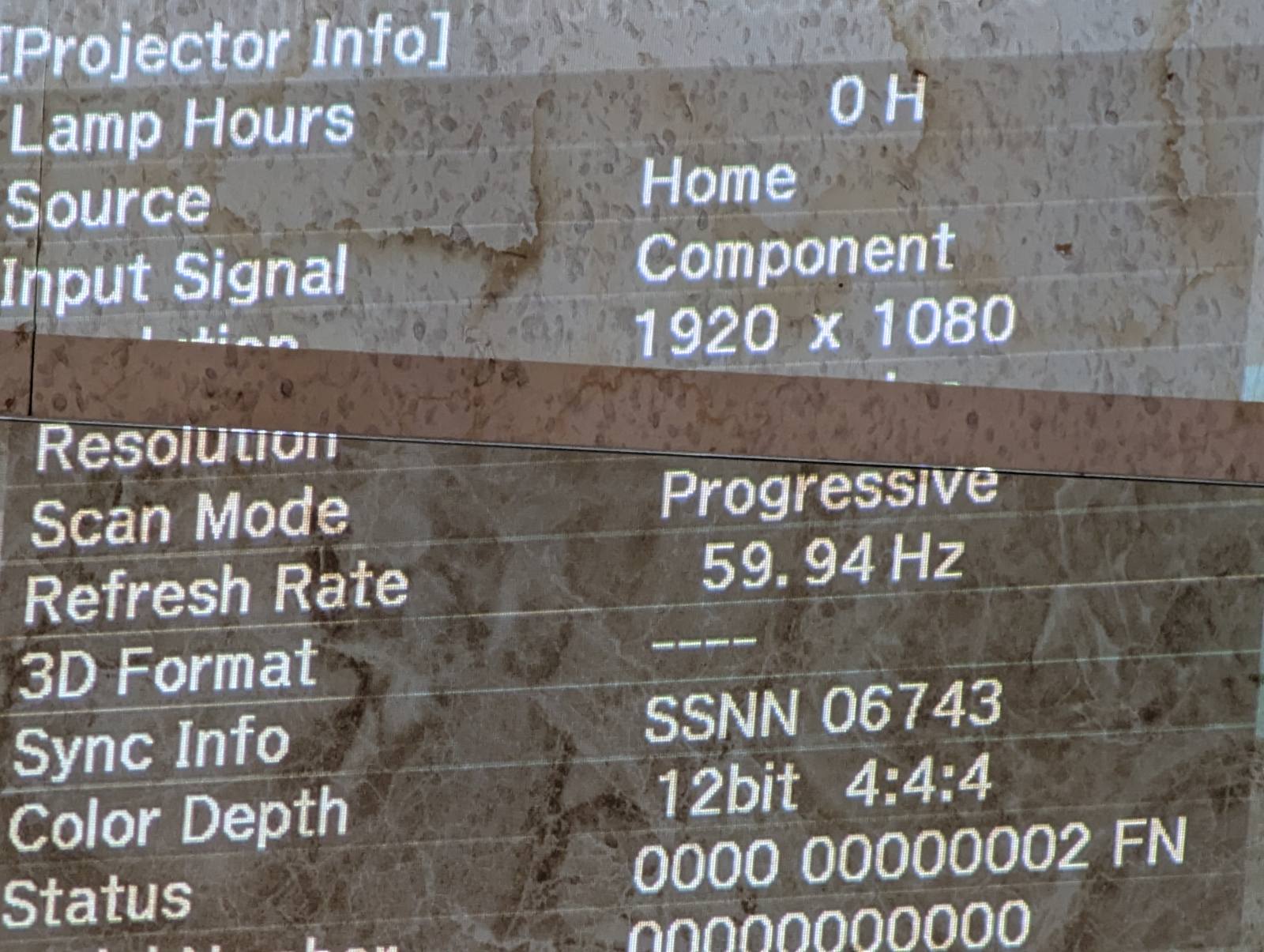 Проектор інформація: роздільна здатність 1920x1080, 59.94 Гц, глибина кольору 12-біт, налаштування та діагностика Зображення з меню налаштувань проектора, що показує деталі про роздільну здатність, режим сканування, частоту оновлення, глибину кольору та інформацію про лампу. На дисплеї вказано, що лампа має нуль годин використання, роздільна здатність становить 1920x1080, а частота оновлення — 59.94 Гц. Це зображення може бути корисним для діагностики та налаштування роботи проектора, а також для перевірки технічних параметрів перед ремонтом.