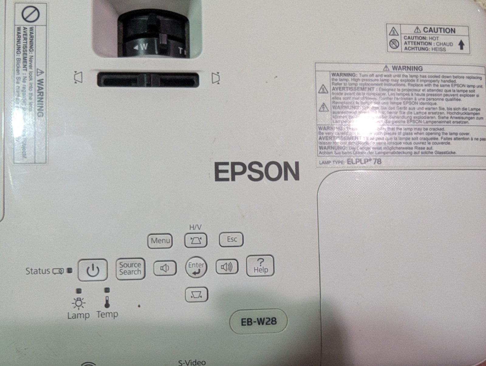 Проектор Epson EB-W28 з кнопками управління та інформаційною наліпкою Проектор Epson EB-W28 з інформаційною наліпкою на корпусі. Видимі кнопки управління, зокрема меню, джерела сигналу та інші функції.