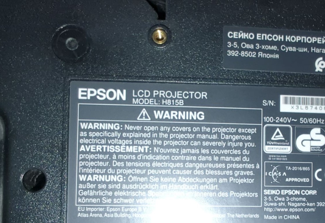 Попередження і технічні дані на проекторі Epson H815B Інформаційна етикетка на Epson LCD Projector модель H815B. Попередження про безпеку та електричні особливості під час ремонту проекторів.
