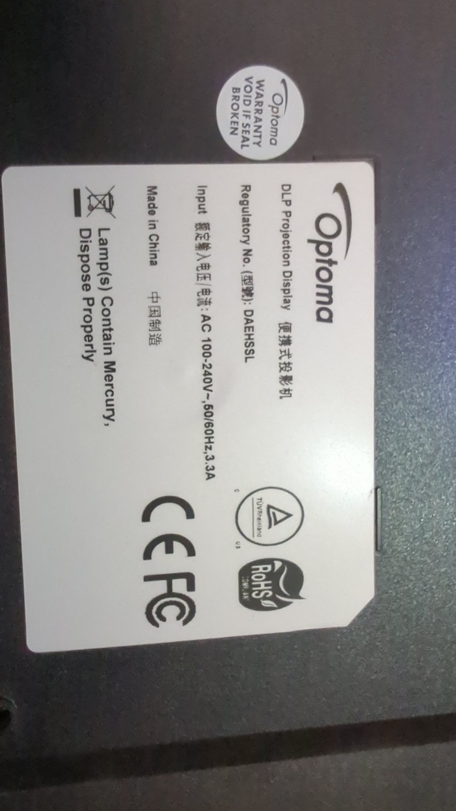 Наліпка на задній частині проектора Optoma DAEHSSL з технічними характеристиками та попередженнями